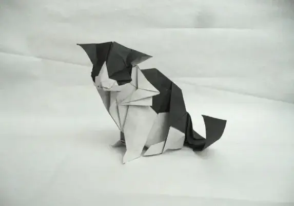 A complex, realistic paper-folding model of a cat featuring a black-and-white color change