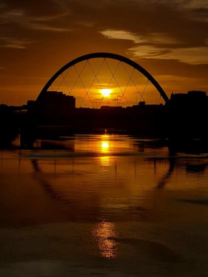 The sun rising directly behind the Squinty Bridge in Glasgow.