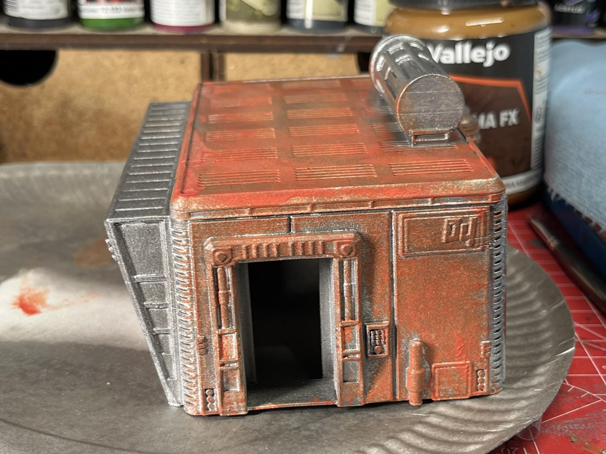 Side view of a badly painted orange sci-fi 28mm scale model building.