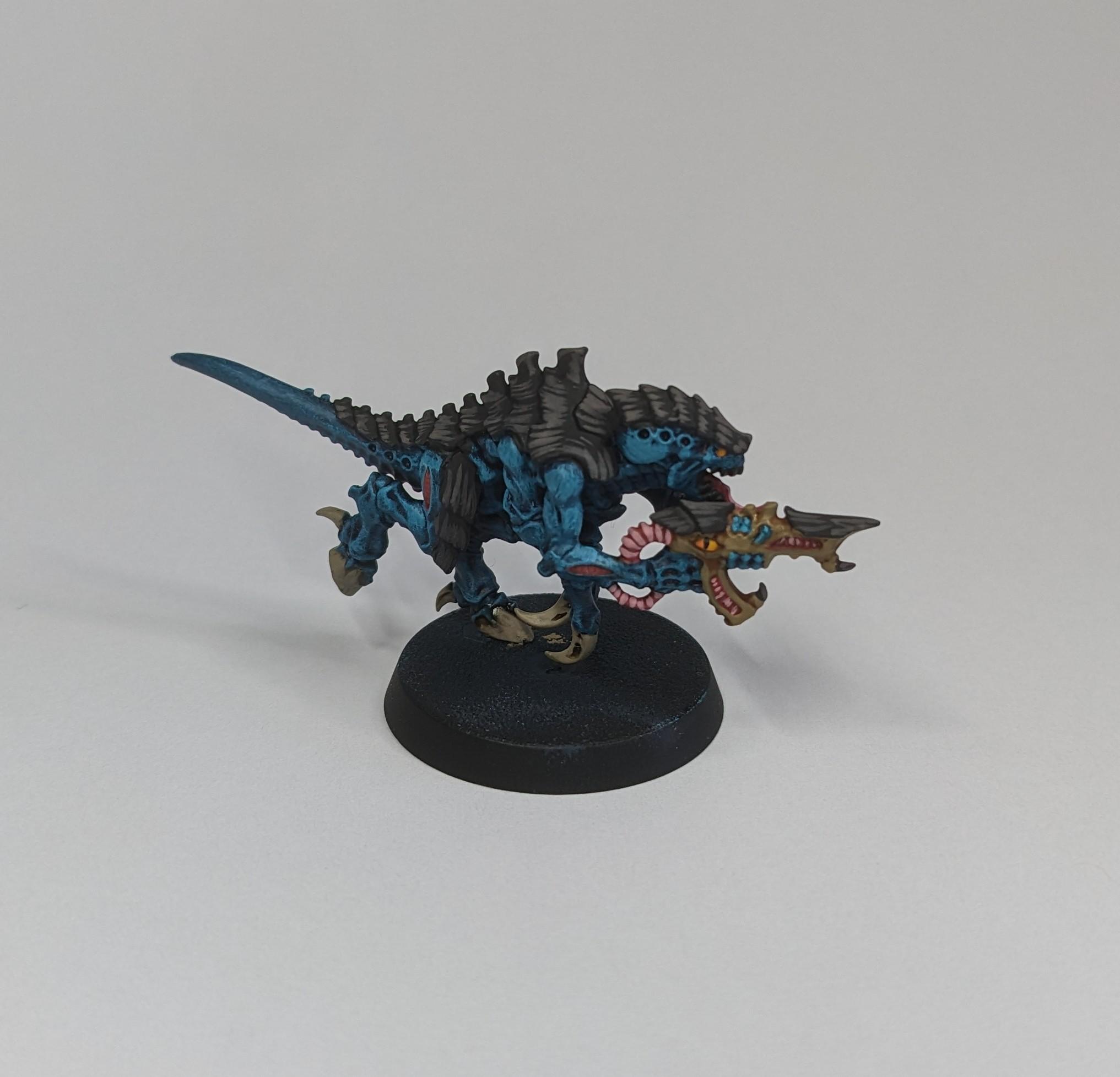 Painted termagant model against a white background. It is painted in the colours of Hive Fleet Oroboros.