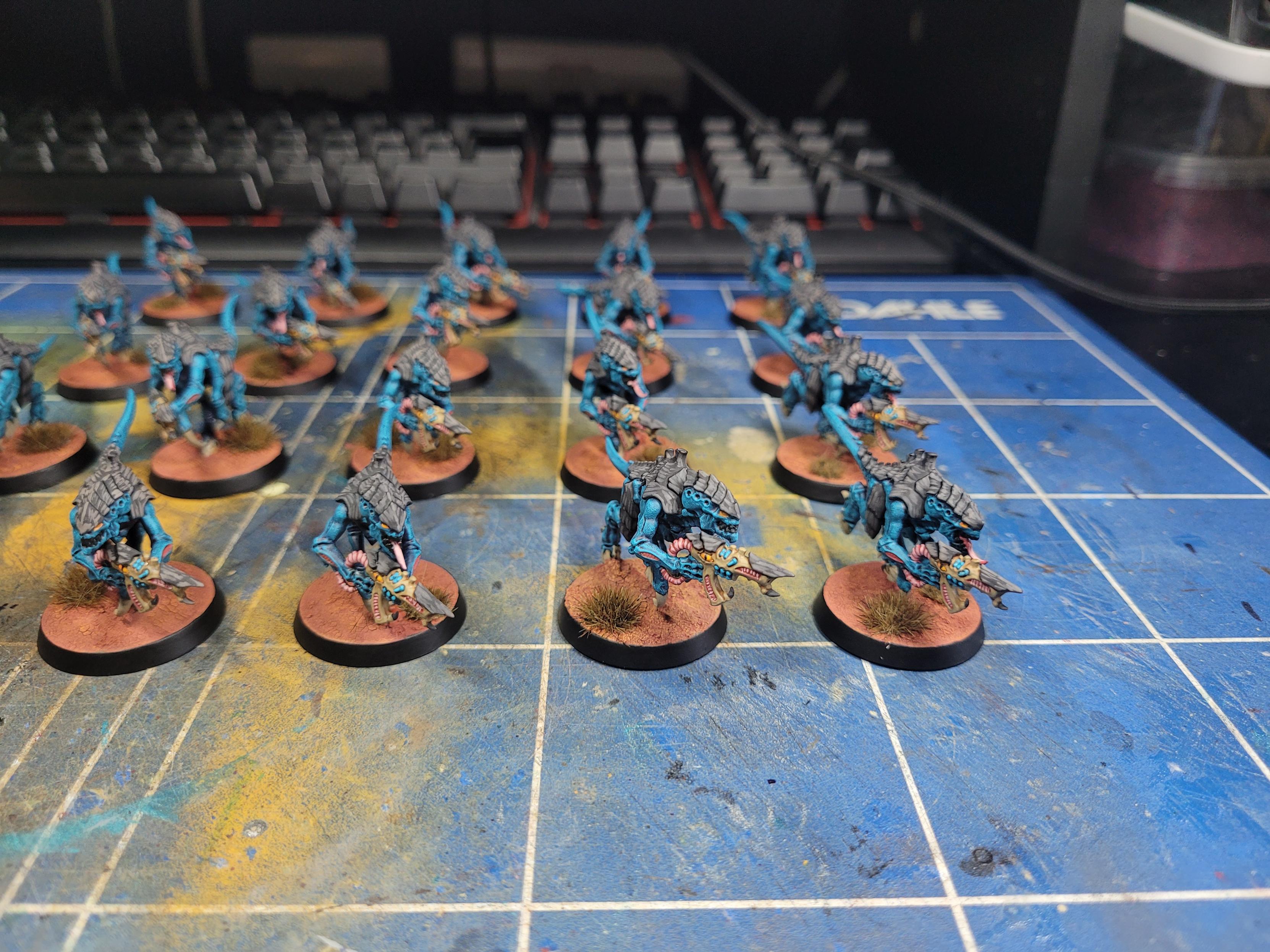 Photo of twenty painted termagants on a cutting mat. They are painted in the colours of Hive Fleet Oroboros. The basing scheme is Martian red in colour with brown dead grass tufts.