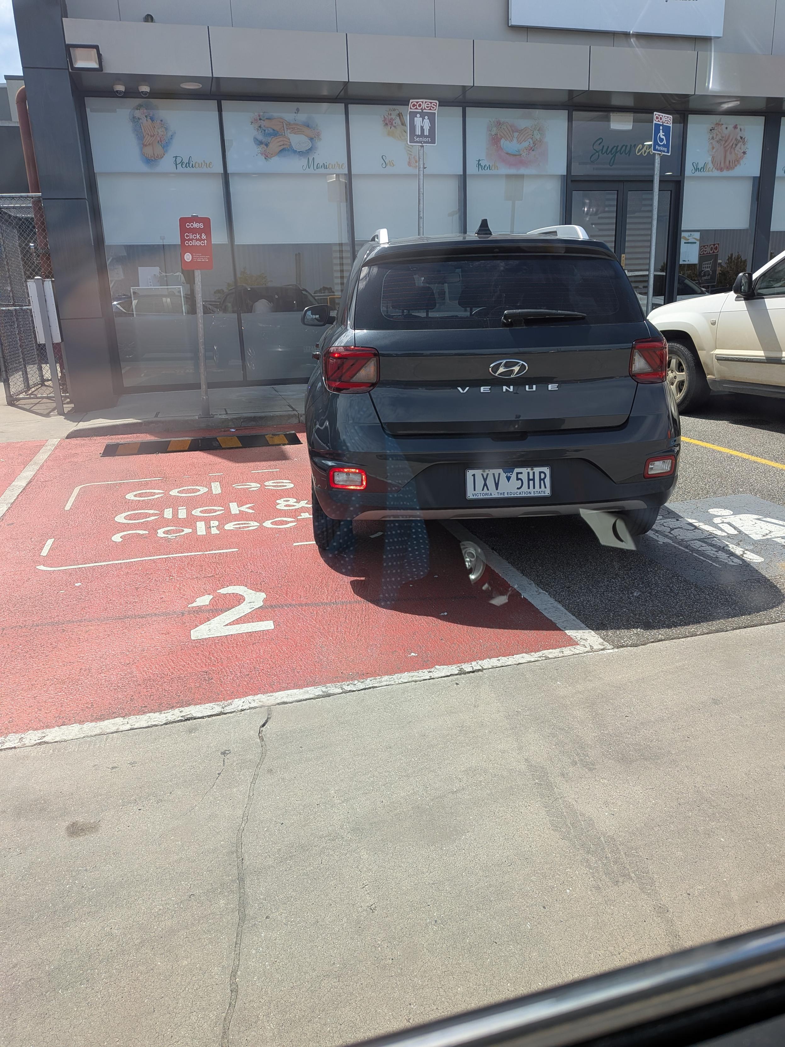 A photo of a car parked crooked in two lanes at once. A grocery pick up and a seniors car spot