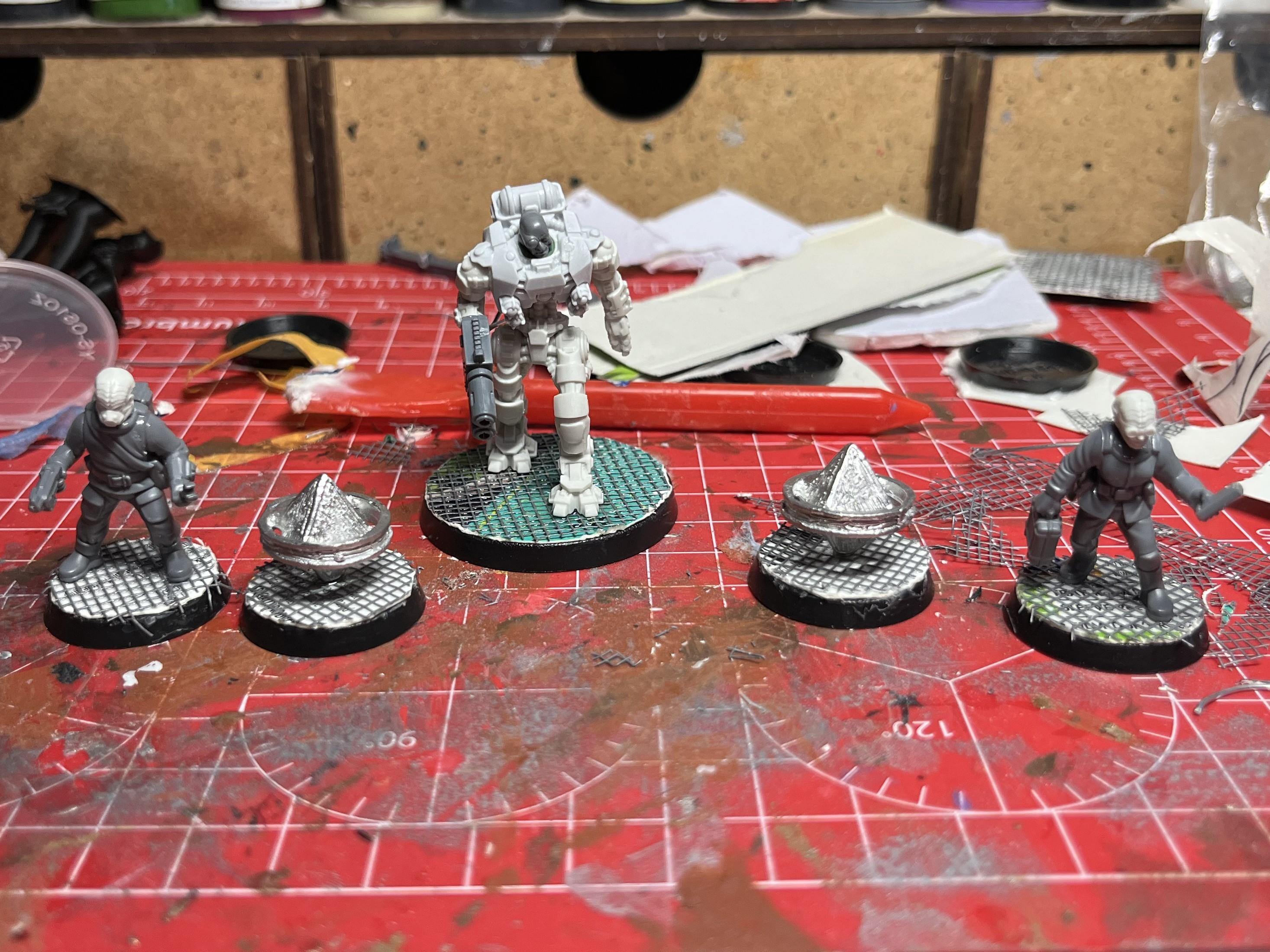 A set of 5 unpainted 28mm sci-fi models. Two of them are humanoids with wrenches and sci-fi tablets, 2 of them are floating square crystal things and one large cyborg with a tall robot body, a multi-melta arm and a human head.