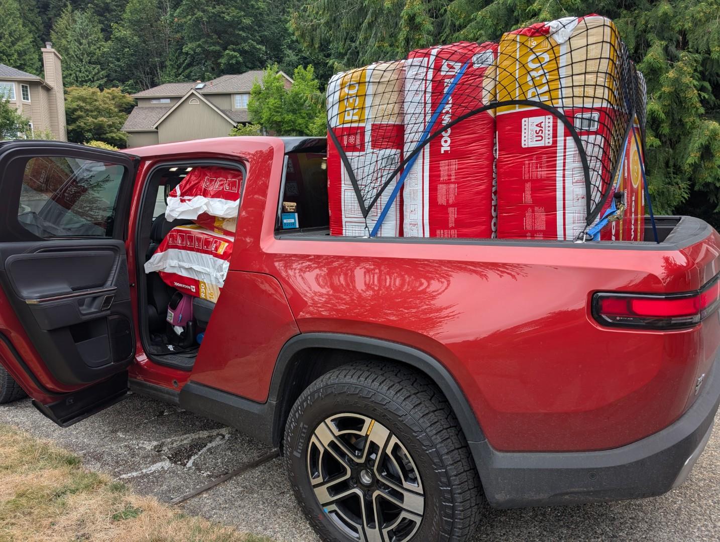 Red pickup stuffed with 8 bags of insulation.