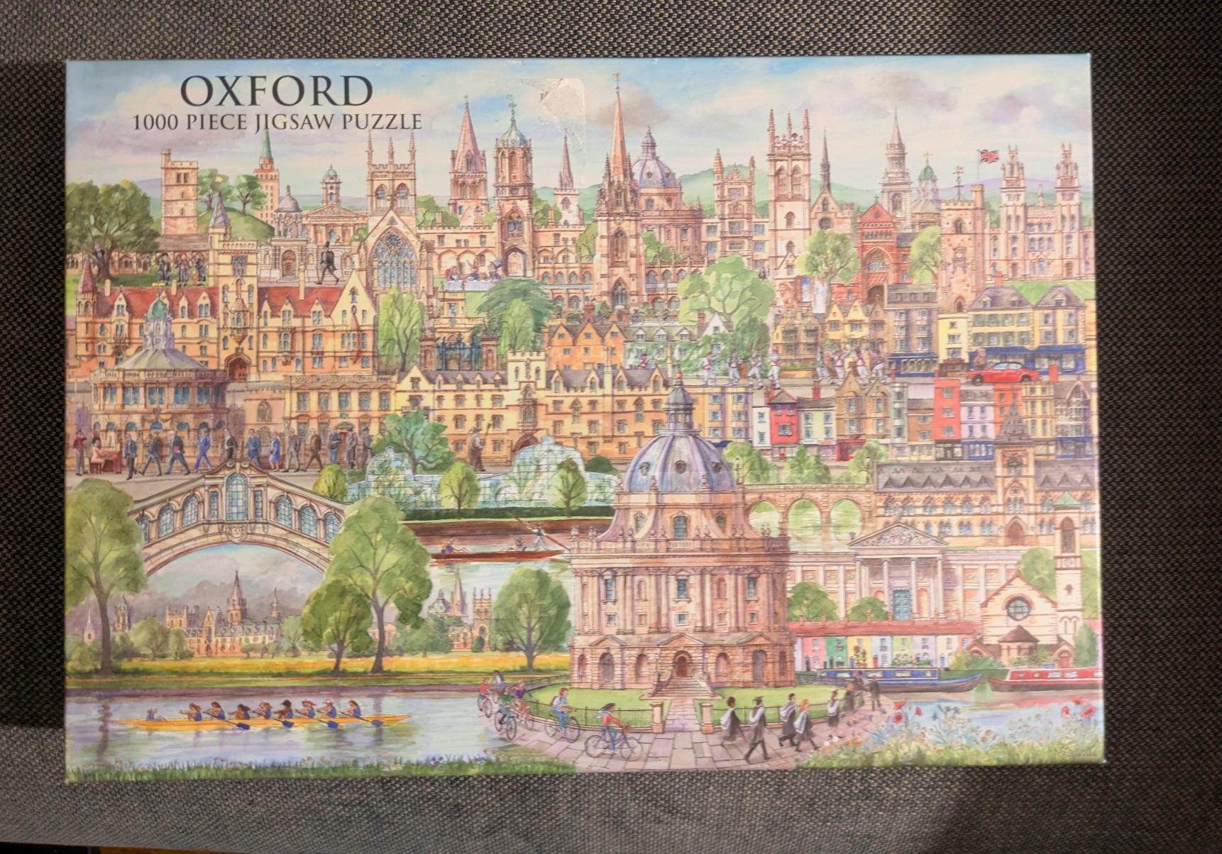 A puzzle box top lid with the text "Oxford 1000 Piece Jigsaw Puzzle" in the top left. The art is a watercolour and ink drawing of a bunch of architectural and famous locations in Oxford.