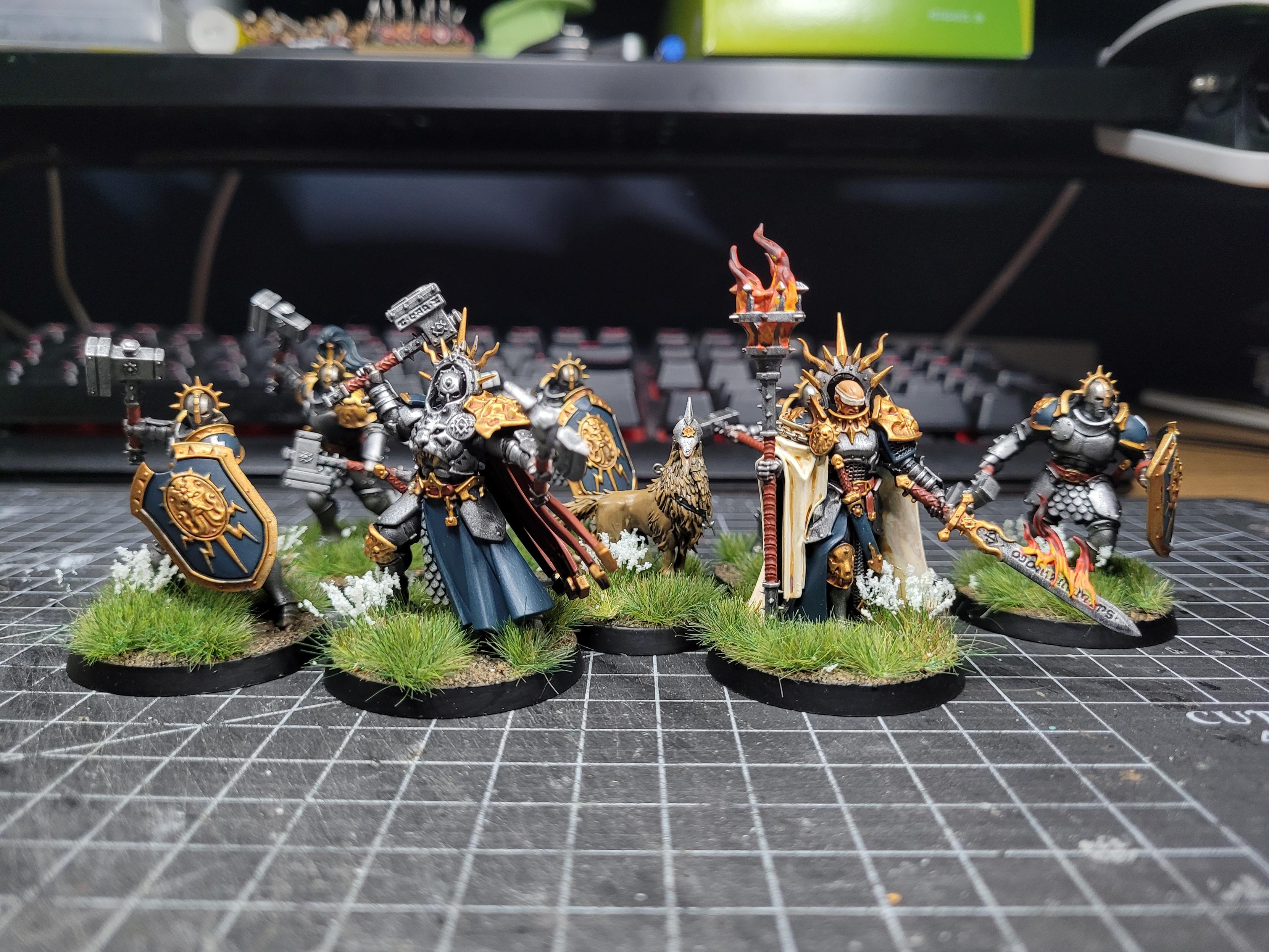 Stormcast Eternal miniatures painted up in the colours of Lightning Hawks; mostly silver armour with a dark teal for the fabric and gold trim.